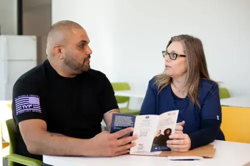 Two veterans looking at a brochure